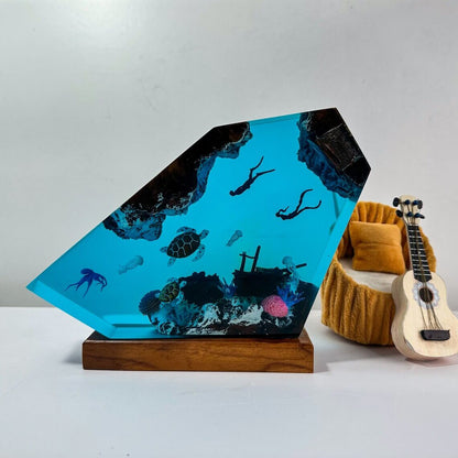 seaweSea Turtle Resin Lamp with Scuba DiverTransport yourself to the magical world under the sea with the Sea Turtle Resin Lamp with Scuba Diver. This handcrafted lamp is a true work of art that brings coastal charm and illuminating ambiance to any space.