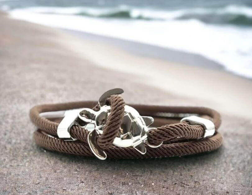 Sea Turtle Rope Bracelet with Silver/Black Charm Treat your wrist to a trendy nautical charm with the sea Turtle Rope Bracelet. This handcrafted accessory brings coastal vibes to any outfit. Key features/benefits: Adjustable rope bracelet with a polished