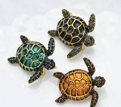 Colored Sea Turtle Hairpin Make a splashy fashion statement with the Colored Sea Turtle Hairpin! This handmade brooch features a playful sea turtle design available in black, dark green, and orange to match any outfit. Whimsical turtle design brings a fun