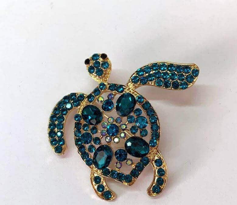 Sea Turtle Hairpin Make a splash with this charming sea turtle hairpin that brings a touch of ocean life to your look. Handcrafted turtle design with intricate textured shell Shimmering blue and green colors evoke the hues of the sea Secures hair in place