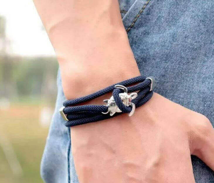 Sea Turtle Rope Bracelet with Silver/Black Charm Treat your wrist to a trendy nautical charm with the sea Turtle Rope Bracelet. This handcrafted accessory brings coastal vibes to any outfit. Key features/benefits: Adjustable rope bracelet with a polished